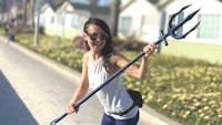 a woman holding a sailor spear on a sidewalk